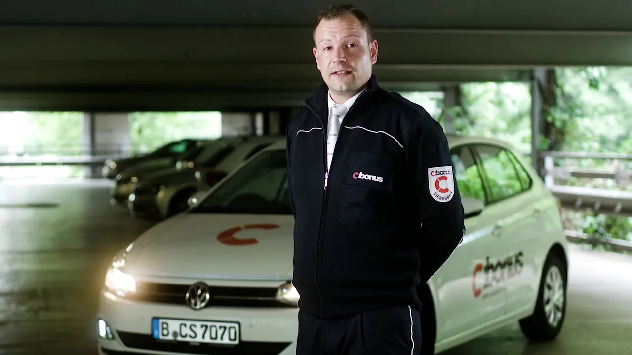 CIBORIUS Mitarbeiter in Uniform vor zwei beschrifteten Einsatzfahrzeugen in einem Parkhaus